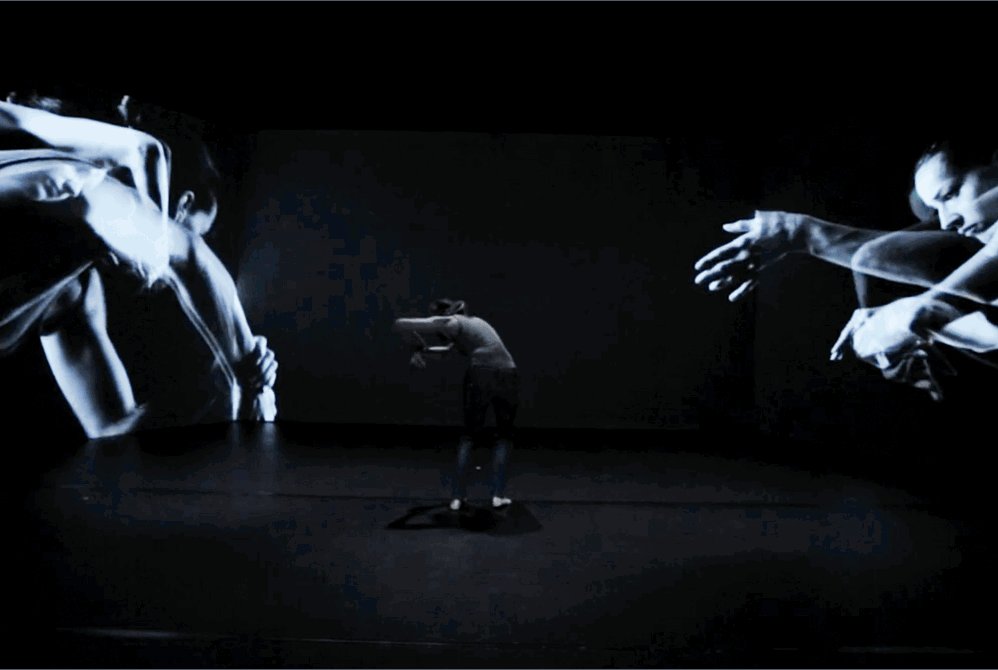 Danser med videoprojeksjon av seg selv bak