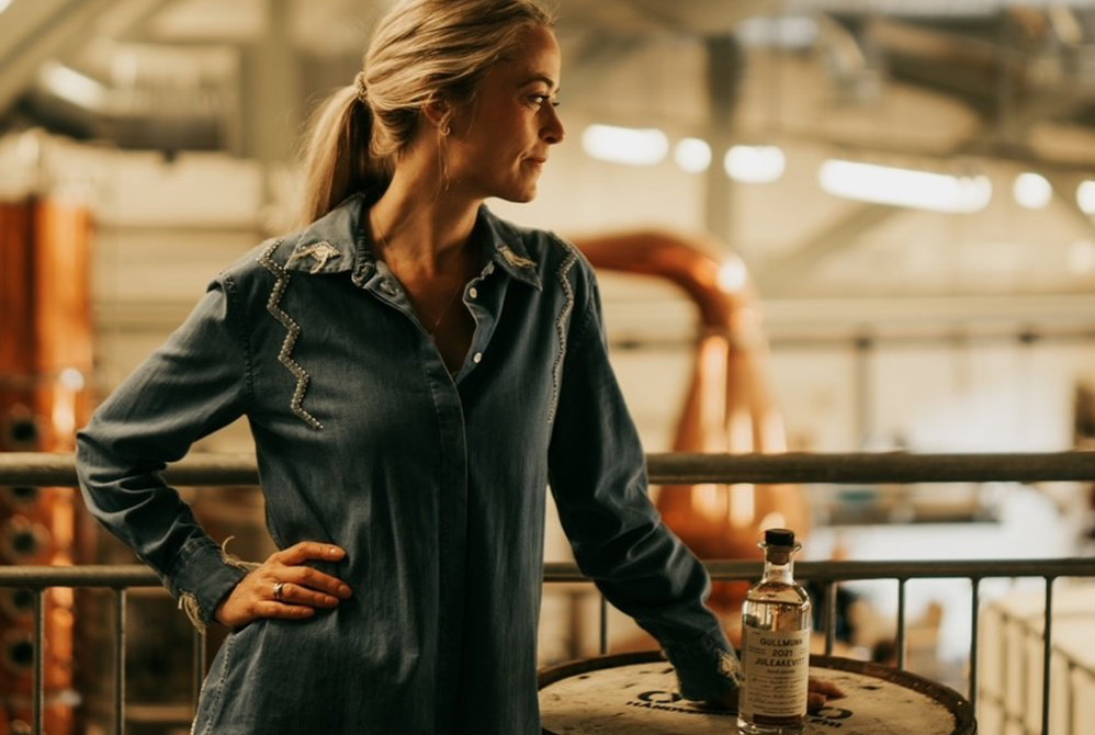 Marthe Bøhn lener seg mot en tønne mens hun ser ned til siden. 