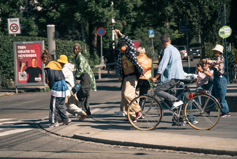 En man danser i gaten mens flere er rundt han. 