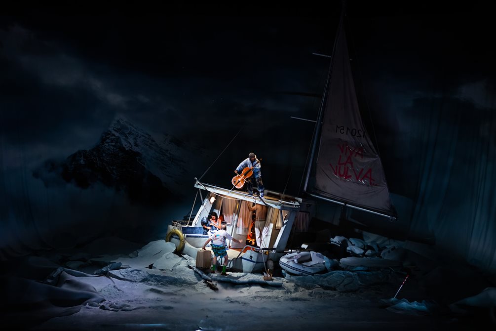 En seilbåt er forlist i et isøde på scenen. På dekk står en mann og spiller cello